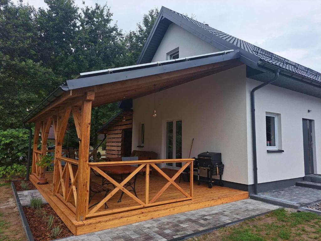 a house with a large deck with a roof at Agroturystyka nad Brusieńką in Cieszanów