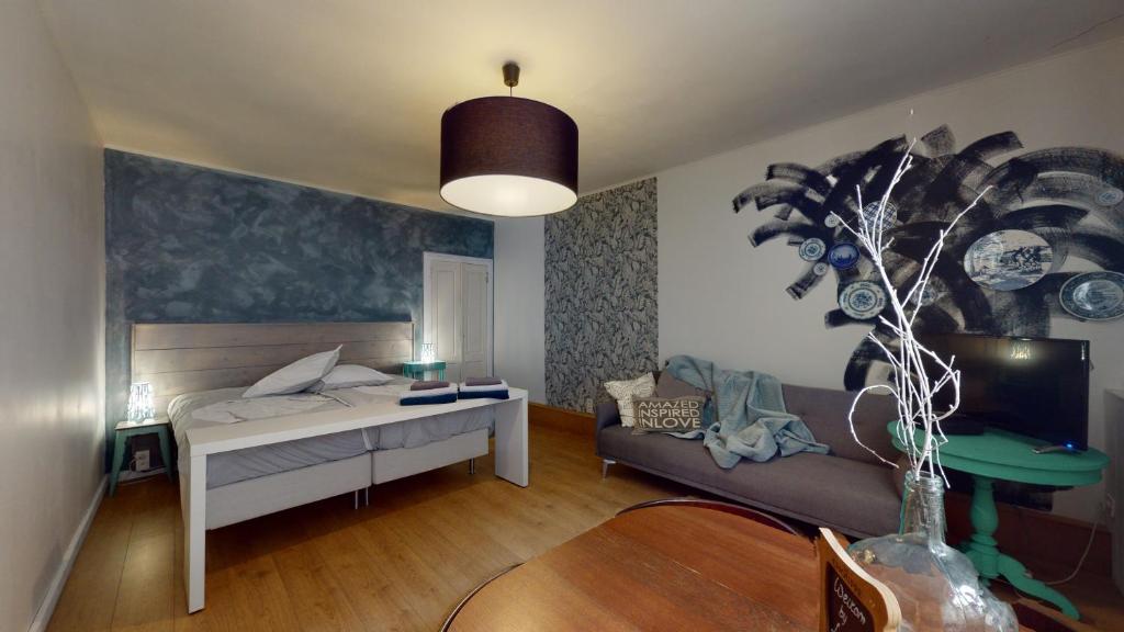 a bedroom with a bed and a couch in a room at Lo-Ghis Vakantieappartement Voerstreek 4P - 2slpk in Voeren