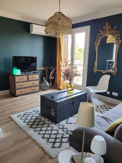 un salon avec un canapé et un miroir dans l'établissement Mini Penthouse, à Avignon