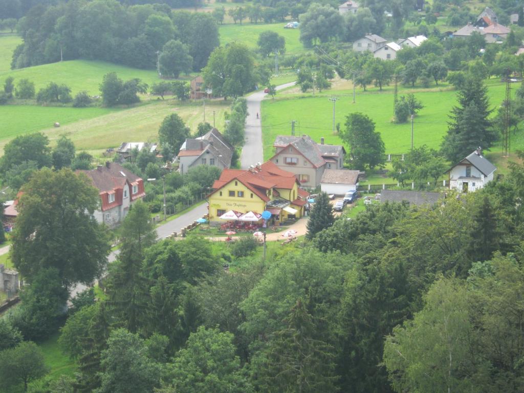 una pequeña ciudad con una casa amarilla en una colina en Guest House Vila Frýdštejn en Frýdštejn