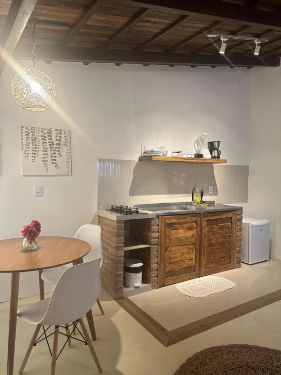 a kitchen with a table and a counter and a table and chairs at Manay Flats in Jericoacoara