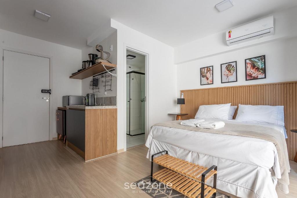 a bedroom with a large bed and a kitchen at Stúdio na Liberdade 270m do metrô MOL0502 in Sao Paulo