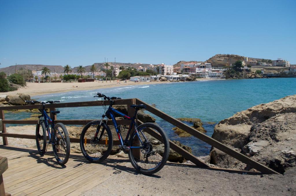 two bikes parked on a boardwalk next to the beach at Mar de Pulpí Costa de Almeria by Mar Holidays in San Juan de los Terreros