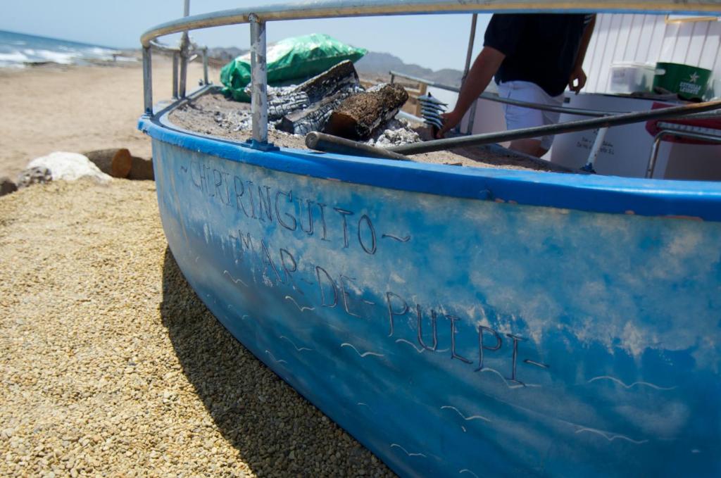 a blue boat sitting on the beach at Mar de Pulpí Costa de Almeria by Mar Holidays in San Juan de los Terreros