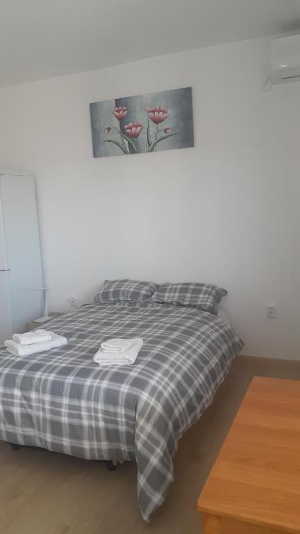 Bett in einem Zimmer mit einem Bild an der Wand in der Unterkunft Komforna Soba U Centru #3 in Mladenovac