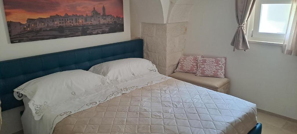- un lit avec une tête de lit bleue dans une chambre dans l'établissement Trullo Ritunno, à Locorotondo
