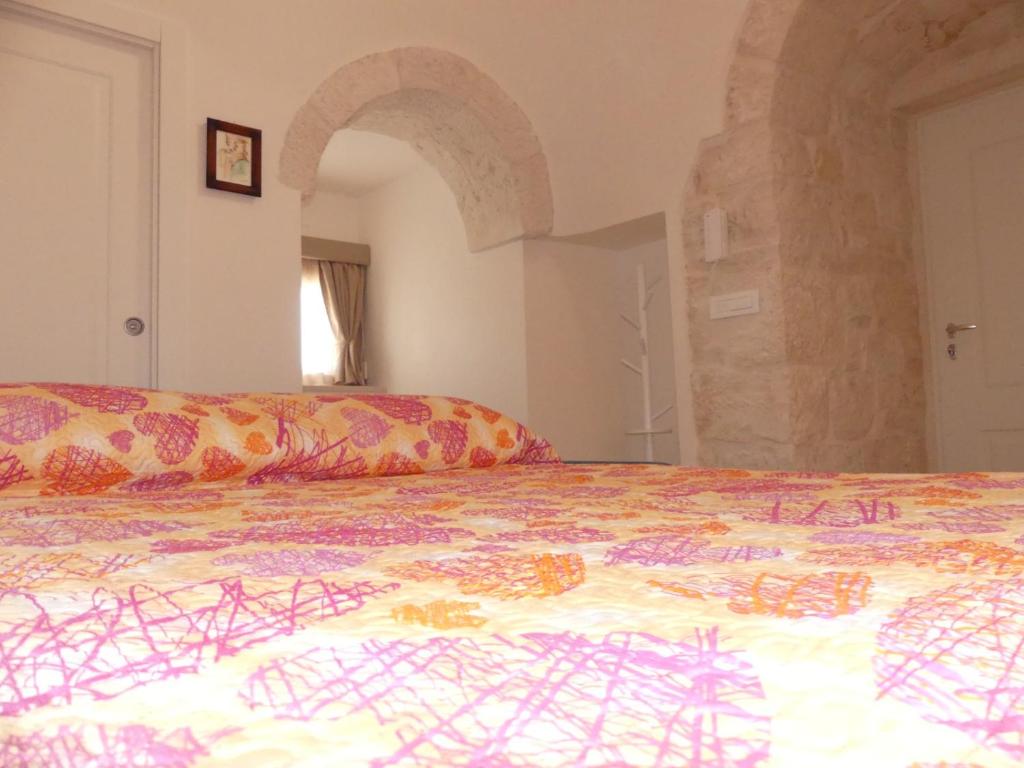 un lit avec une couverture colorée dessus dans l'établissement Trullo Ritunno, à Locorotondo
