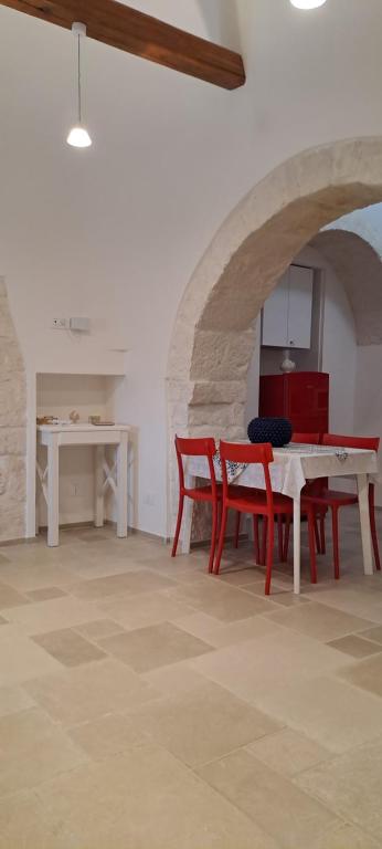 une salle à manger avec une table et des chaises rouges dans l'établissement Trullo Ritunno, à Locorotondo