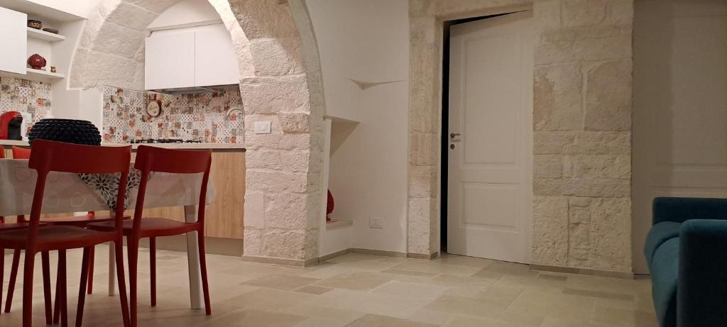 une cuisine avec une table et des chaises dans une pièce dans l'établissement Trullo Ritunno, à Locorotondo 30 autres photos
