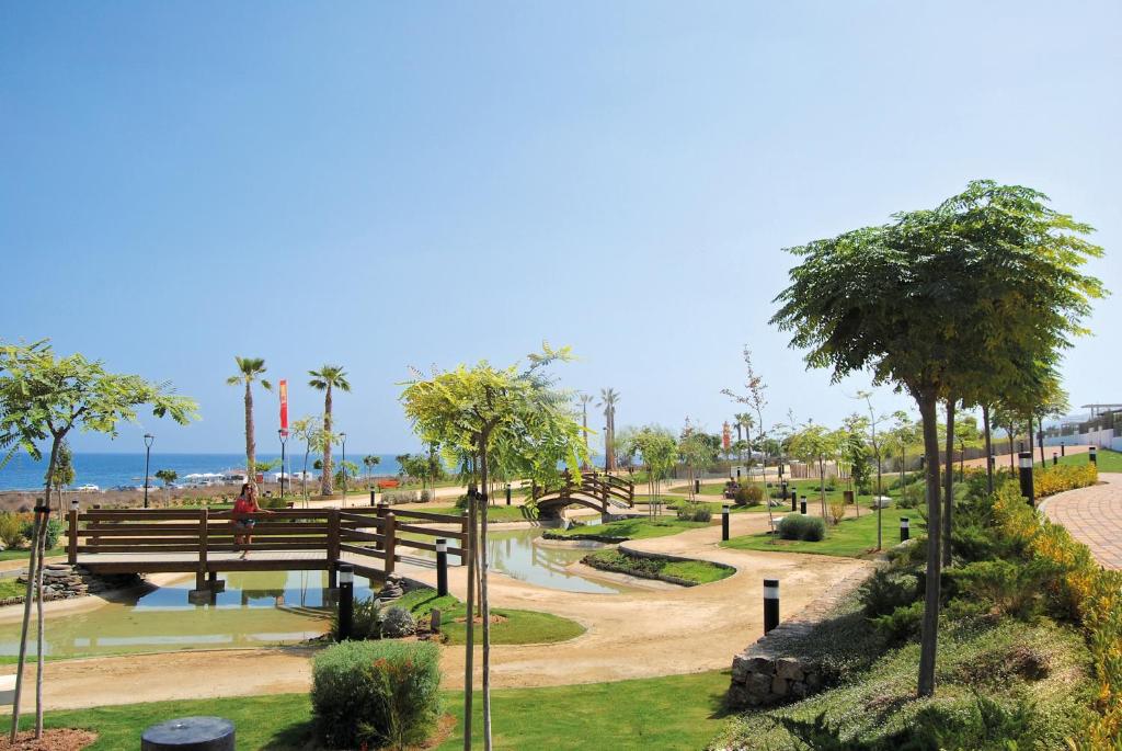 a park with a wooden bridge over a pond at Mar de Pulpí Costa de Almeria by Mar Holidays in San Juan de los Terreros