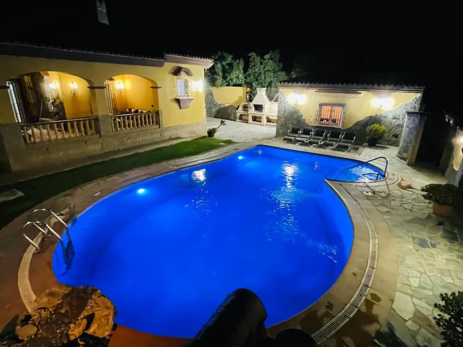 a large blue swimming pool in front of a house at La Almadraba in Chiclana de la Frontera