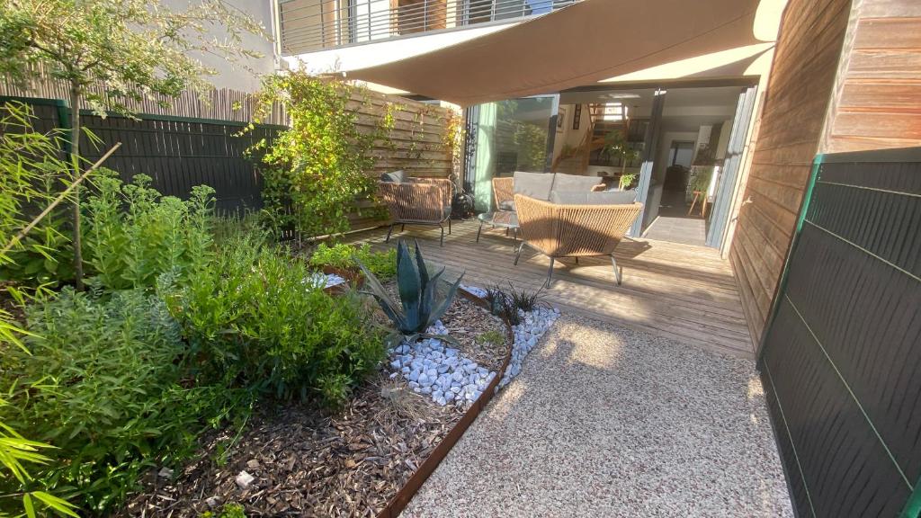 un patio avec une chaise et des plantes dans une cour dans l'établissement La Douceur Tourangelle, à Tours