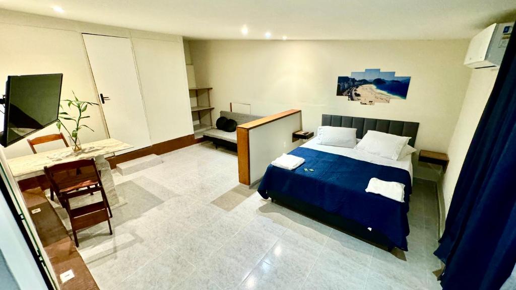 a bedroom with a blue bed and a desk at Rio Deal Guest House in Rio de Janeiro