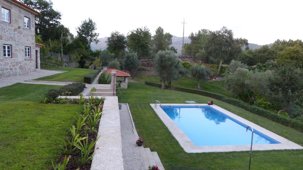 a backyard with a swimming pool and a house at Quinta do Correia in Cabeceiras de Basto