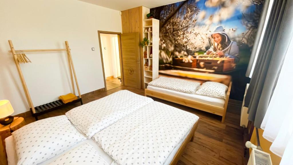 a bedroom with two beds and a painting on the wall at Apartmány SVRČINKY in Liptovský Mikuláš