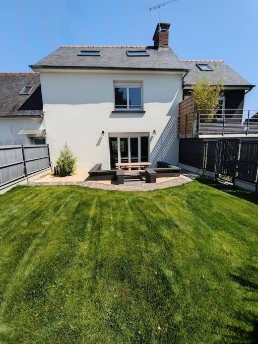 une maison blanche avec une cour avec une pelouse dans l'établissement Les brumes du Mont Saint Michel, à Beauvoir