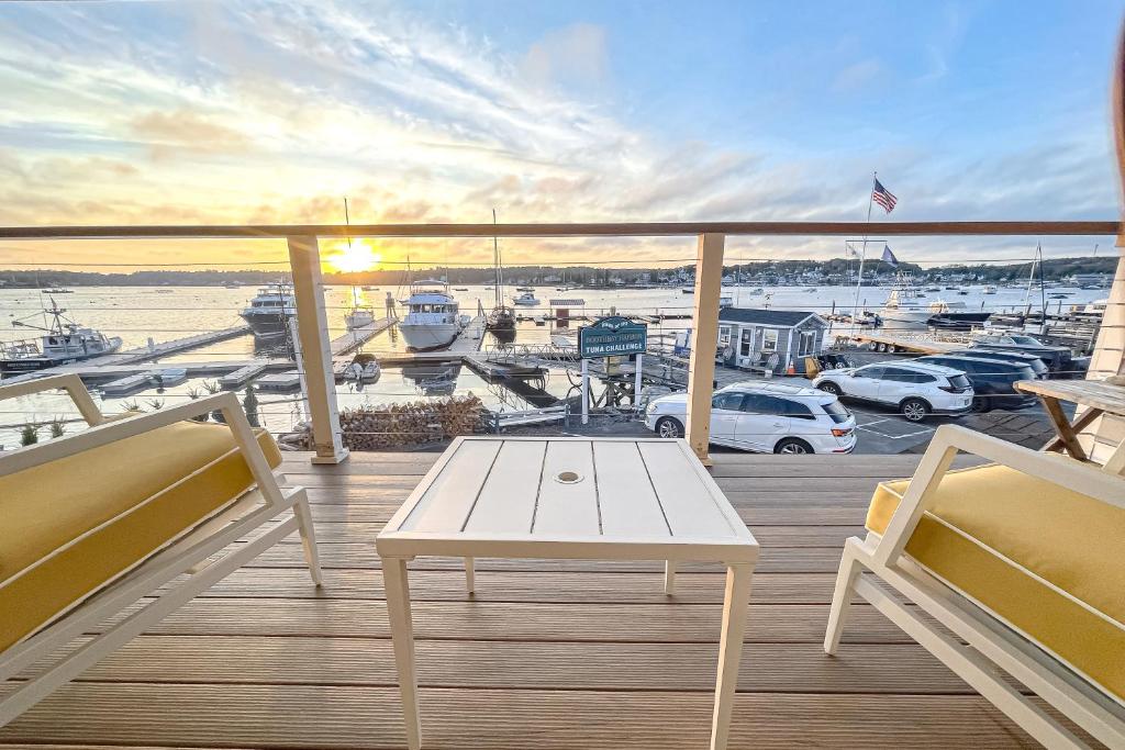 Un balcón con una mesa blanca y vista a un puerto deportivo. en Ocean Breeze Condo, en Boothbay Harbor