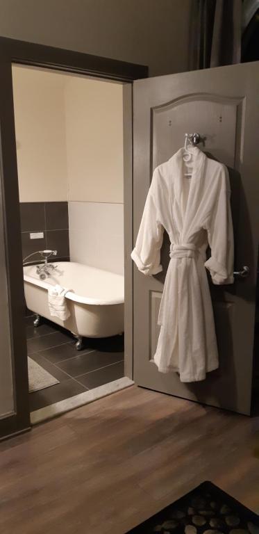 a robe hanging in a bathroom with a bath tub at Oberge Inn Val-David in Val-David