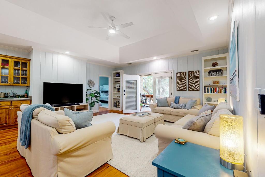 een woonkamer met twee banken en een tv bij Natural Wonder in Edisto Island