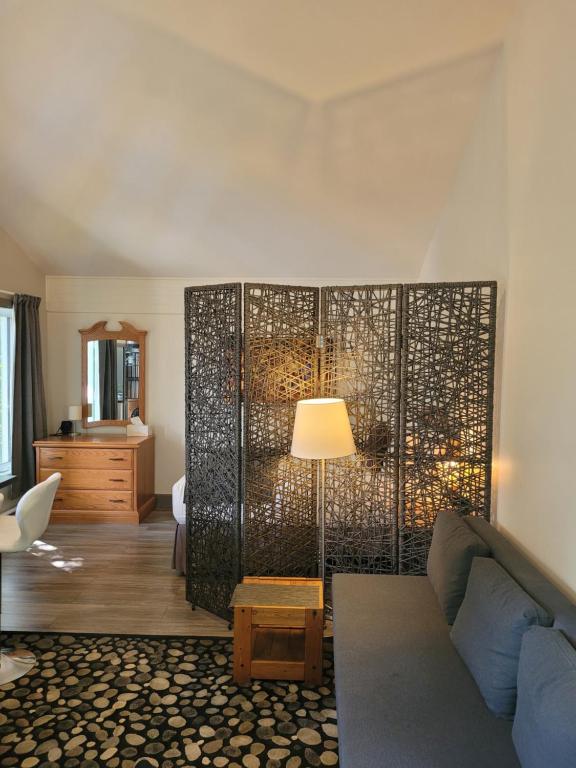 a living room with a couch and a lamp at Oberge Inn Val-David in Val-David