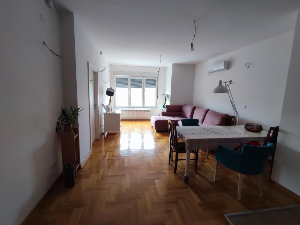 una sala de estar con una mesa y un sofá en Room in a nice sunny apartment, en Vračar (historical)