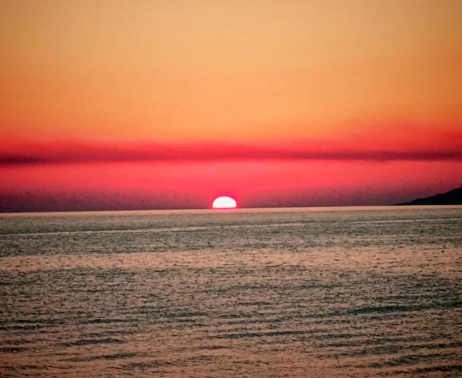 a sunset over the ocean with the sun in the horizon at La Foggia seaside paradise in Siculiana