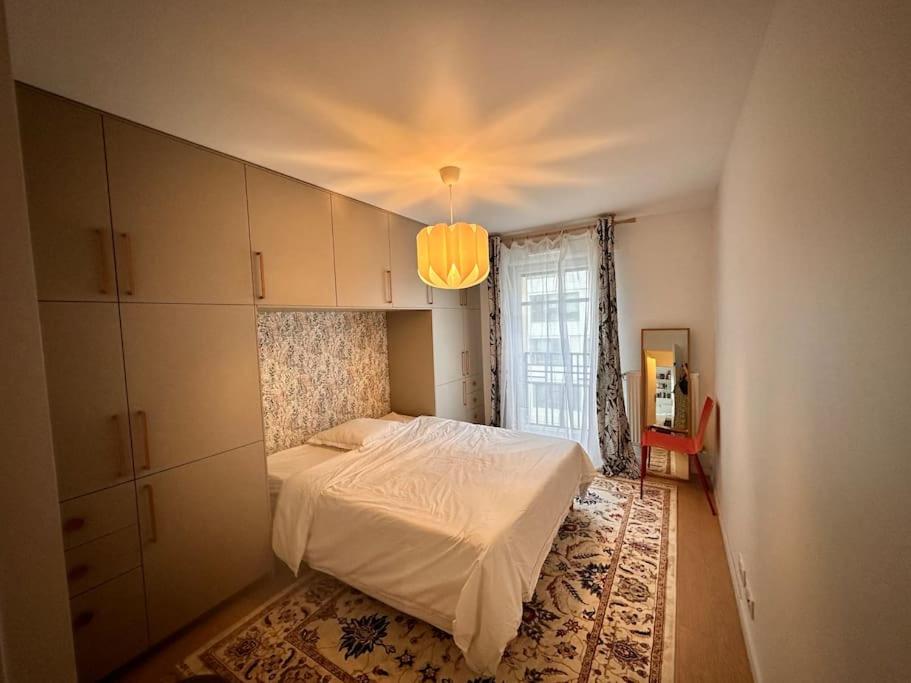 une chambre avec un lit blanc et une fenêtre dans l'établissement Appartement à 10 min centre Paris métro 13 et 14, à Saint-Ouen