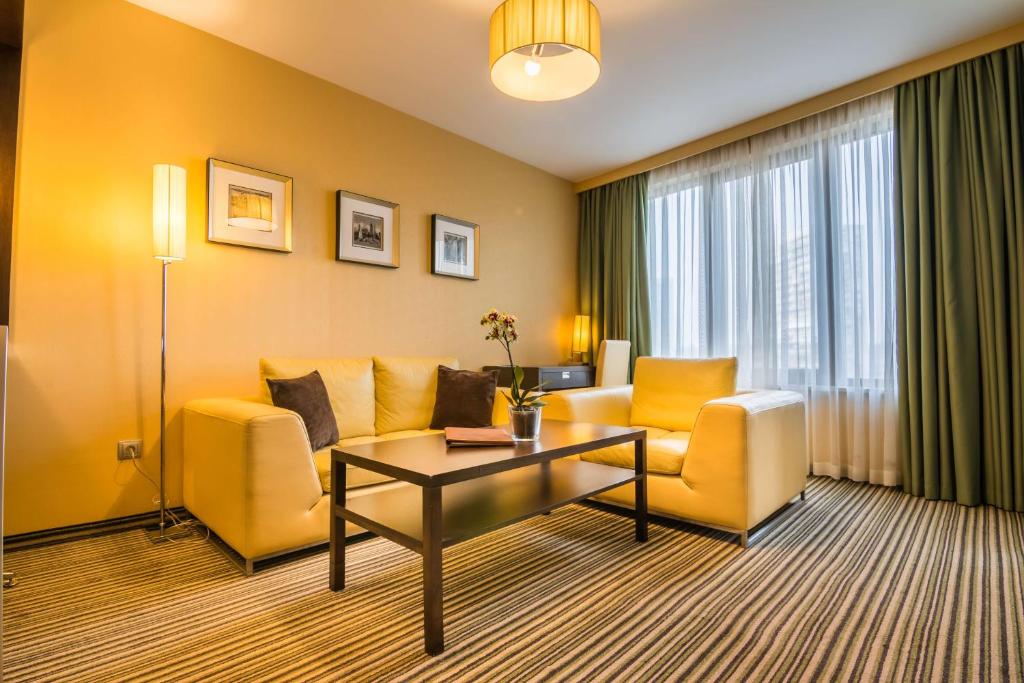 een woonkamer met een bank en een tafel bij Best Western Plus Olives City Hotel - Free Pool & Parking in Sofia
