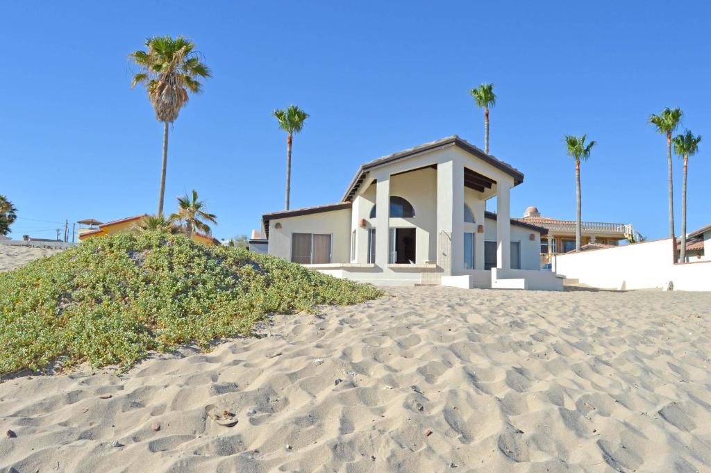 a house on the beach with palm trees at Playa Romantica in Puerto Peñasco