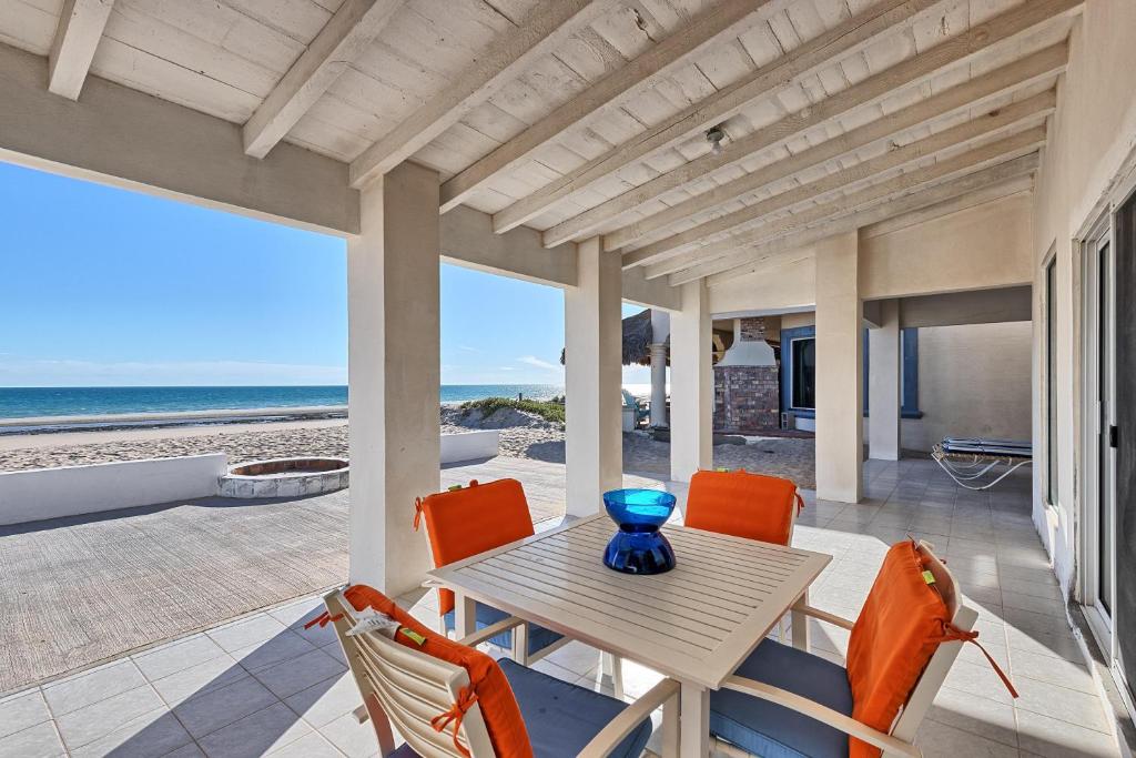 a porch with a table and chairs and the ocean at La Perla in Playa Encanto