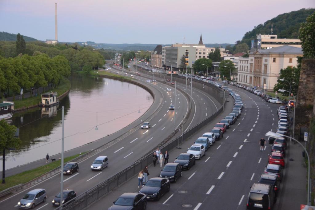 a highway with cars parked next to a river at GQ Deluxe Apartment in Saarbrücken