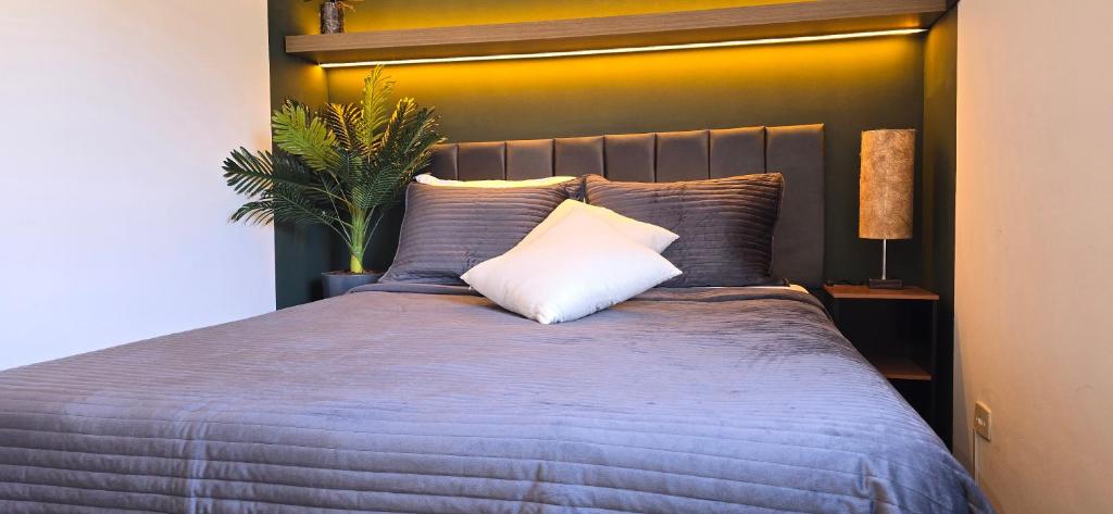 a bedroom with a large bed with a white pillow at Apartamento Confortável Inteligente in Poços de Caldas