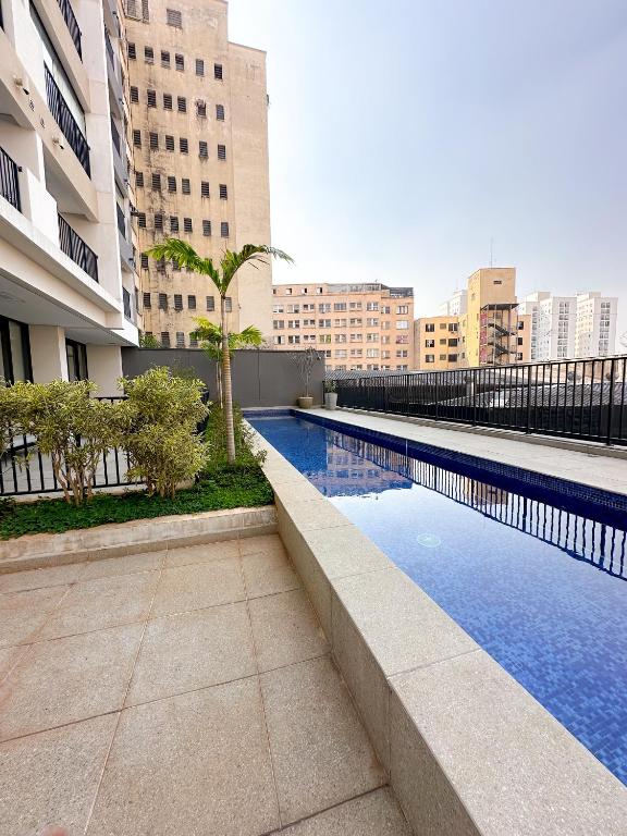 a swimming pool in a city with tall buildings at Blue Apto Automatizado Moderno in São Paulo