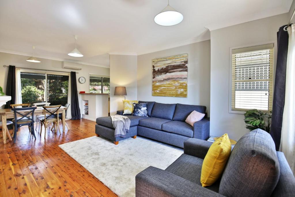 a living room with a blue couch and a table at Queen Street Cottage - By Berry Getaways in Berry