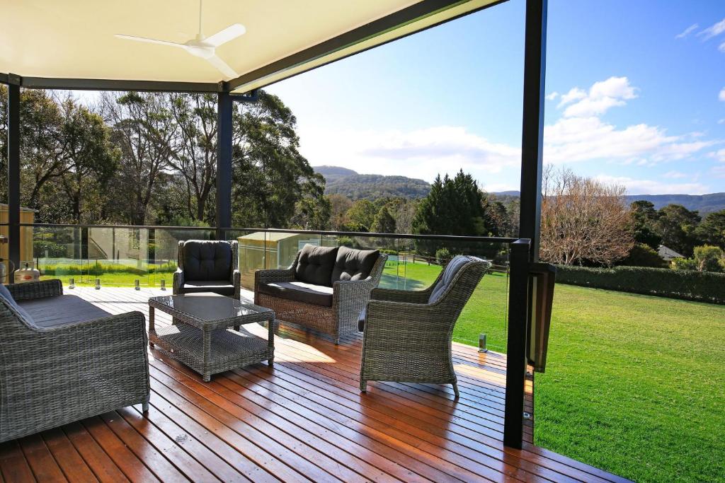 a patio with chairs and a table on a deck at Floriel - By Berry Getaways in Berry