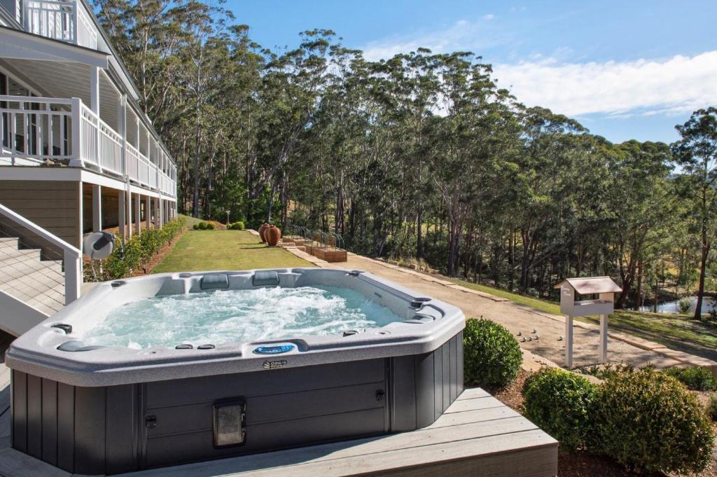 a hot tub in the backyard of a house at Possum Gully Lodge -By Berry Getaways in Berry
