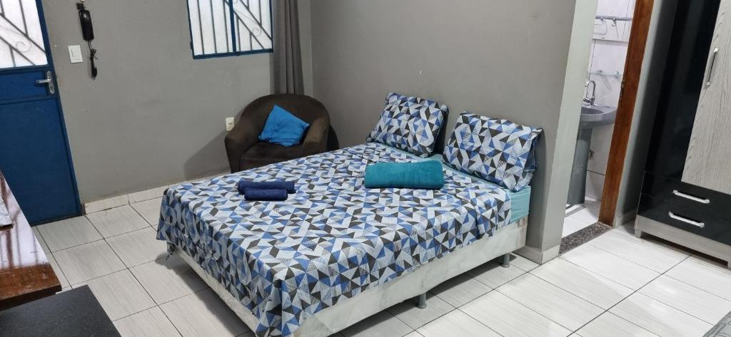 a bedroom with a bed with blue sheets and a chair at Vila 789 in Manaus