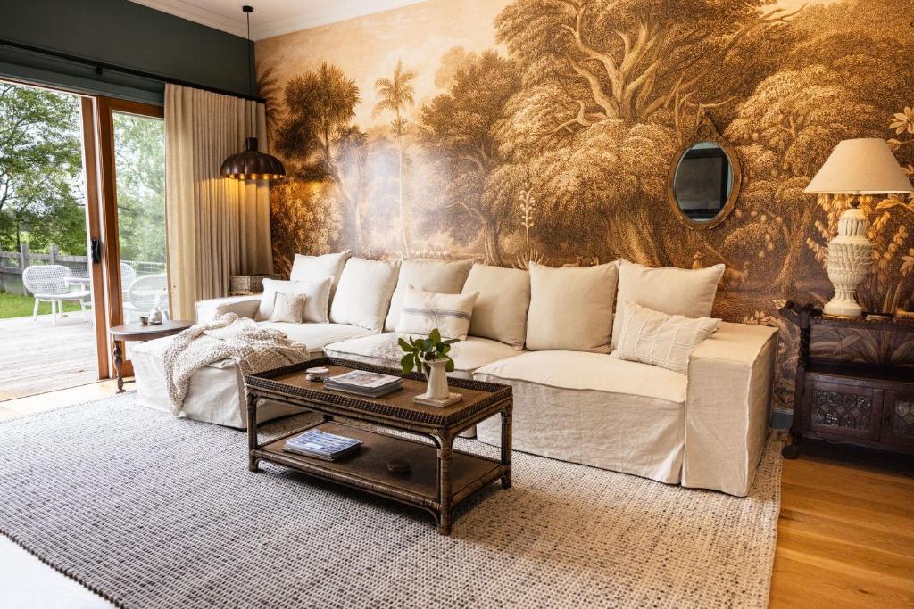 a living room with a couch and a table at Mabel's Cottage - By Berry Getaways in Berry