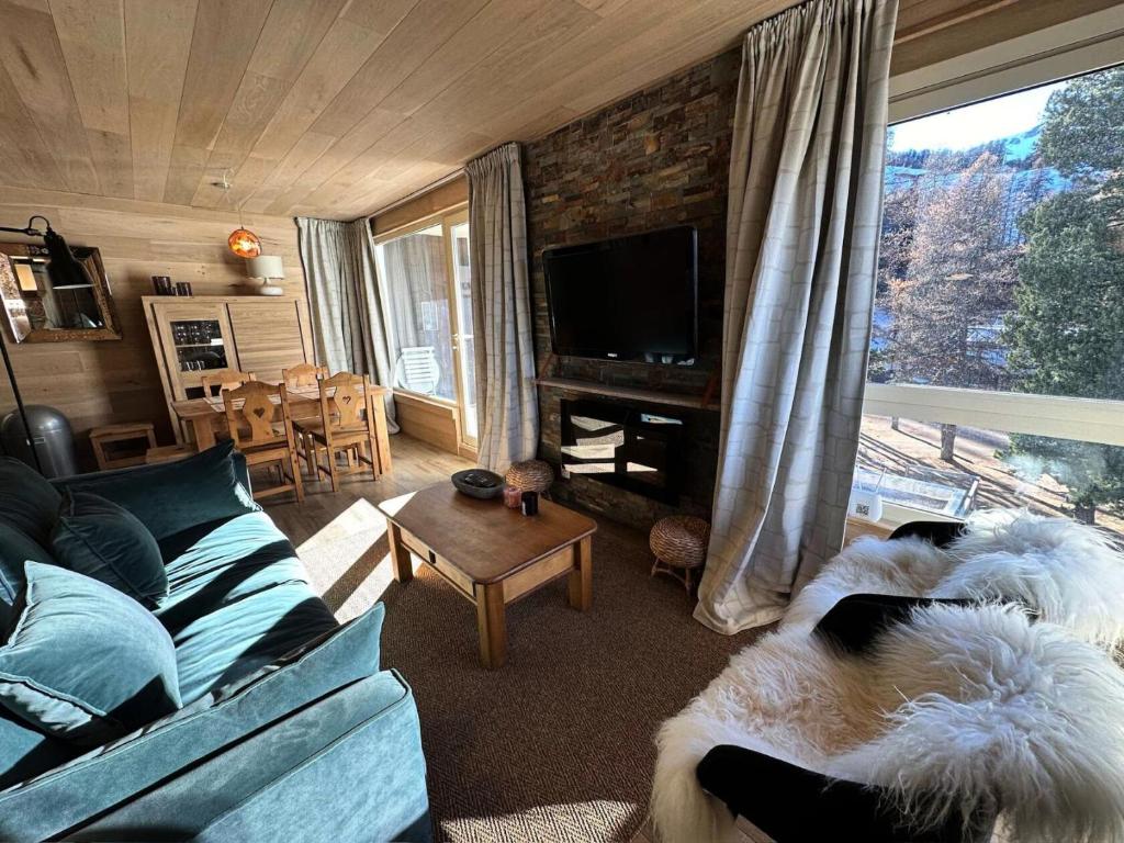 un salon avec un canapé et une télévision dans l'établissement Le Panestrel (residence) - RESIDENCE LE PANESTREL MAE-9991, à Vars