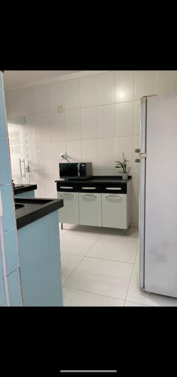 a white kitchen with a white refrigerator in it at Condomínio paixão 4 in Aparecida