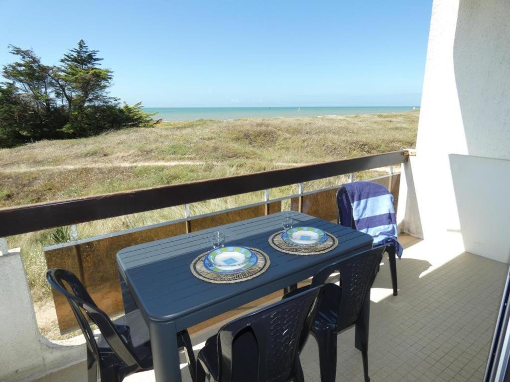 - une table bleue et des chaises sur un balcon donnant sur la plage dans l'établissement Appartement rénové, 2 chambres, balcon, parking, face mer - FR-1-540-295, à Notre-Dame-de-Monts