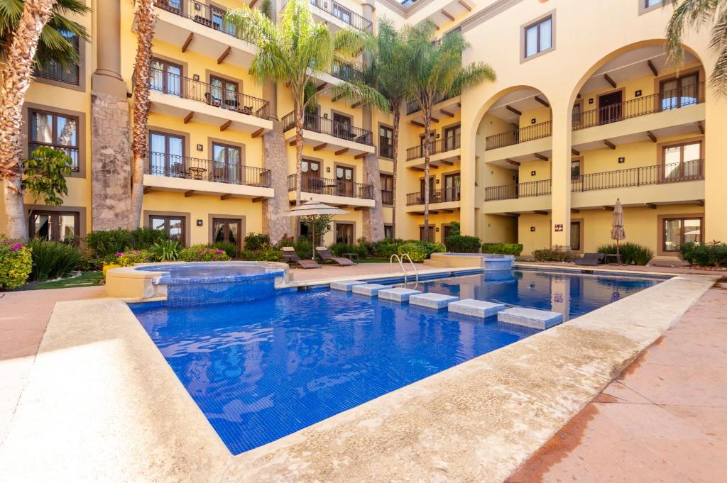una piscina di fronte a un edificio con palme di Luxury Condo Steps Away from Downtown San Miguel a San Miguel de Allende