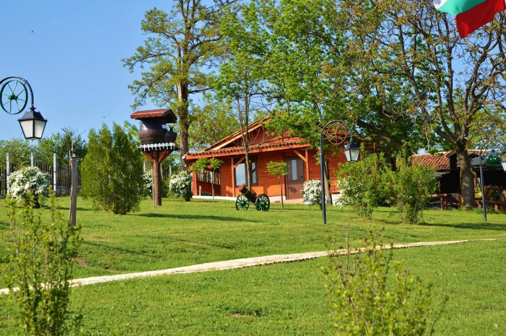a house in a grassy yard with a house at Guest House Kosharite in Byala Ruse