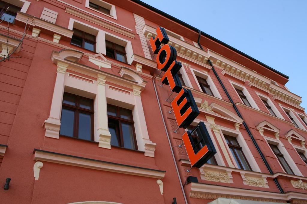 czerwony budynek z napisem przed nim w obiekcie Wellness Hotel Beethoven w mieście Chomutov