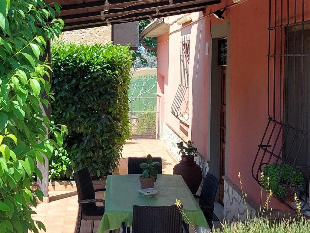 een groene tafel en stoelen op een patio bij Casa Rosata in Magliano Sabina