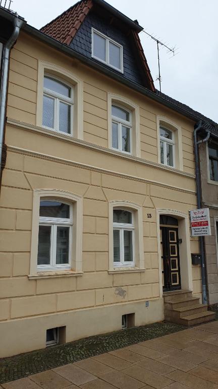 a yellow house with windows and a sign on it at Pension Am Großen Markt in Osterburg