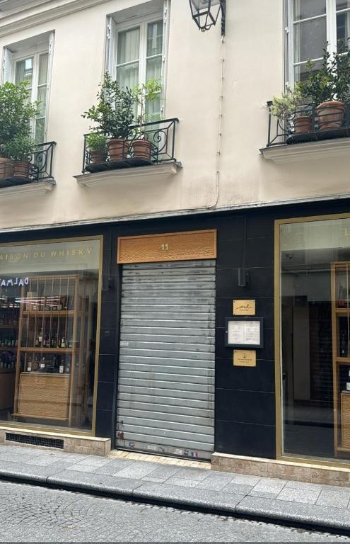un bâtiment avec deux portes de garage dans une rue dans l'établissement Historic paris charme, à Paris
