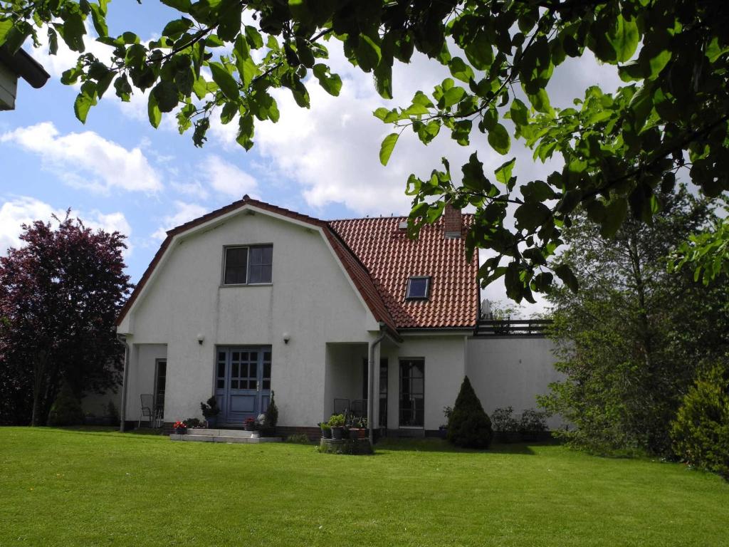 a white house with a red roof on a yard at "Ferien vom Ich" - Fam Roman Kurth in Güstelitz