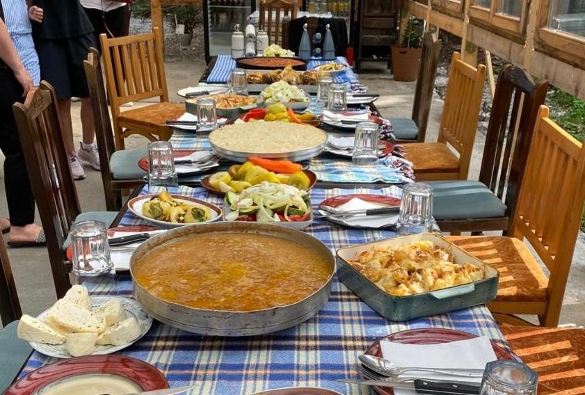 a table full of food on a blue at Guest house Hyrmet Demushi in Valbonë