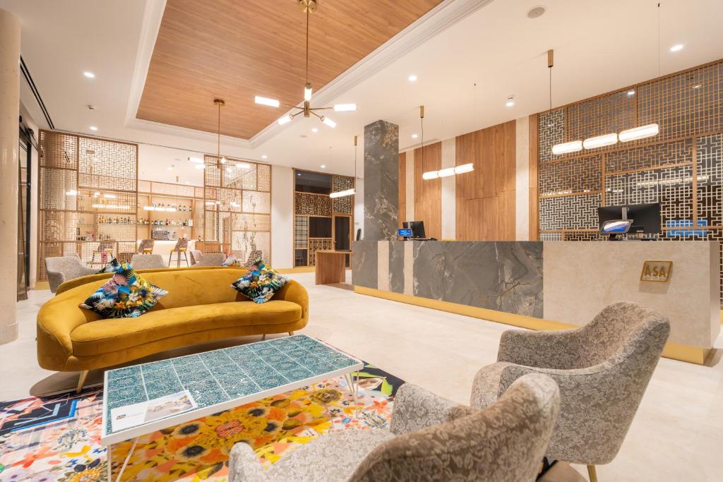 a lobby with a couch and a table and chairs at ASA Hotel La Marina in Ondara